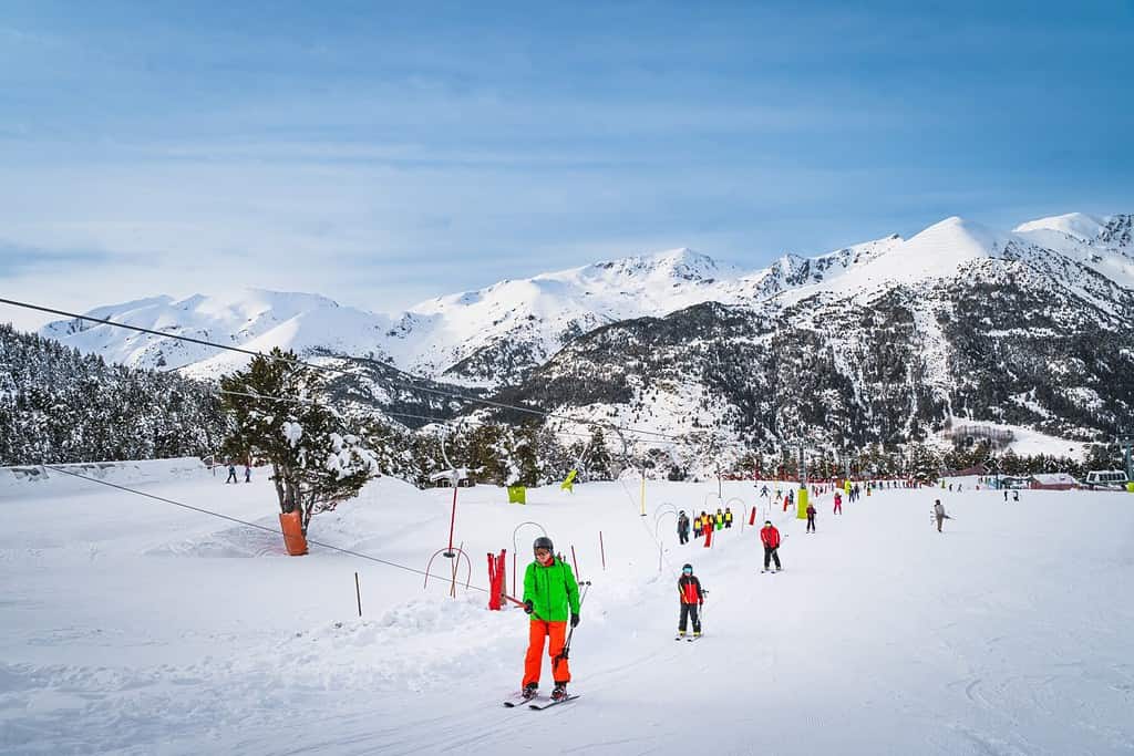 People, adults and kids, skiers and snowboarders going up on drag lift. Ski winter holidays in Andorra, El Tarter, Pyrenees Mountains, Grandvalira