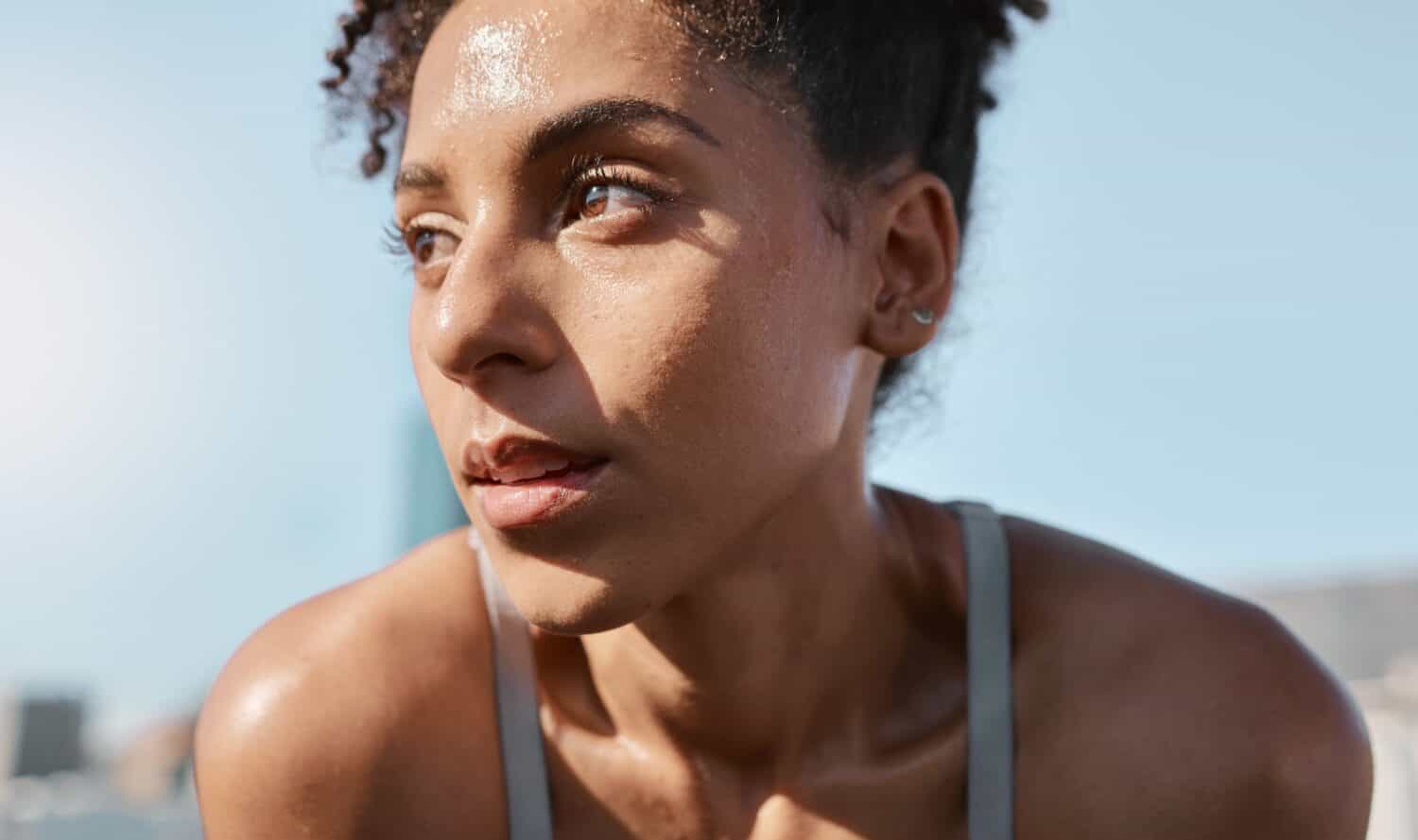 Face, sweat and fitness with a sports black woman tired after a cardio workout for fitness in the city. Running, exhausted and sweating with a female athlete or runner resting after exercise in town