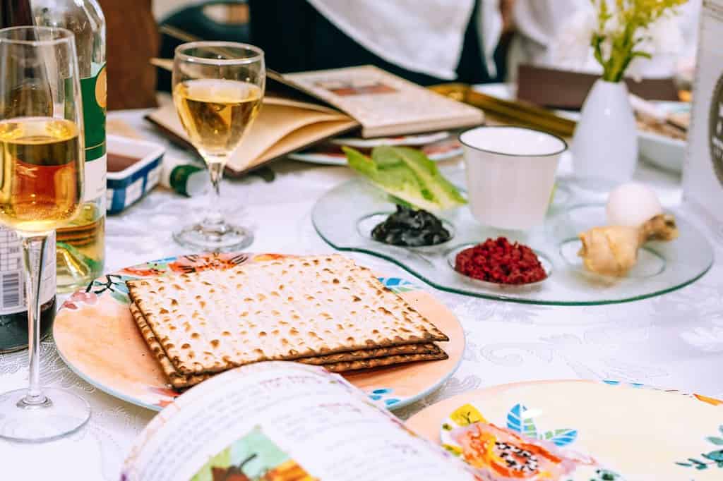 Passover table setting with a traditional Passover seder plate with symbolic meal, matzah and Haggadah. Table served for Passover Seder - Pesach.