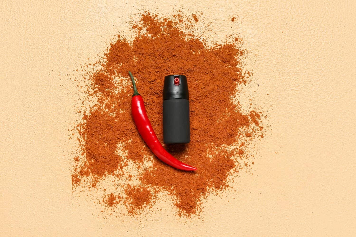 Spray with chili pepper and powder on beige background