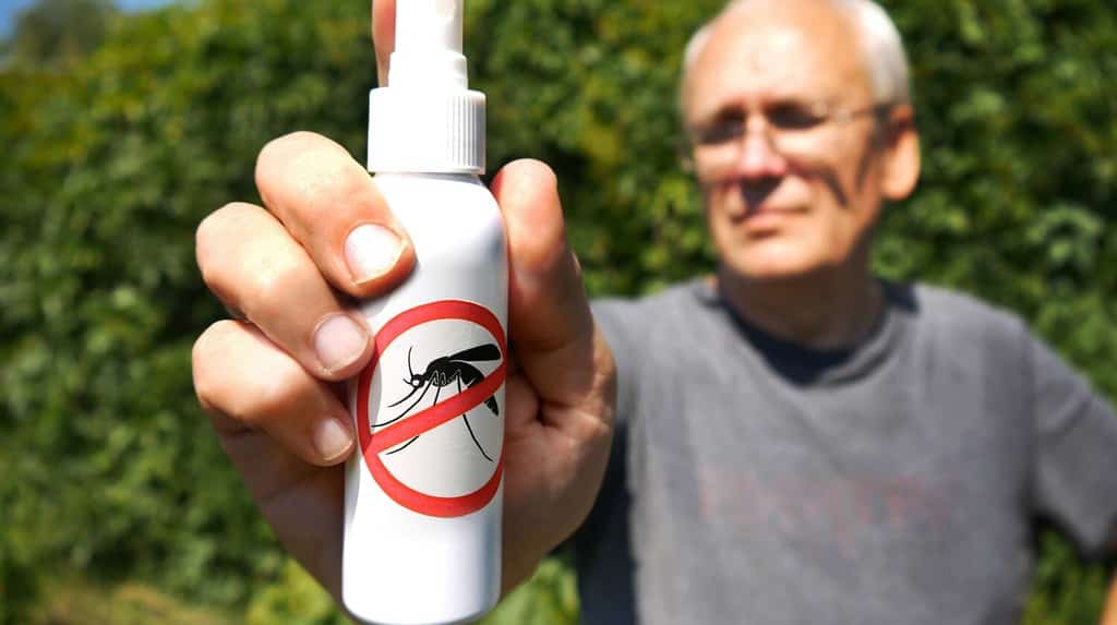 Close-up of the hand of a man holding a mosquito spray tube