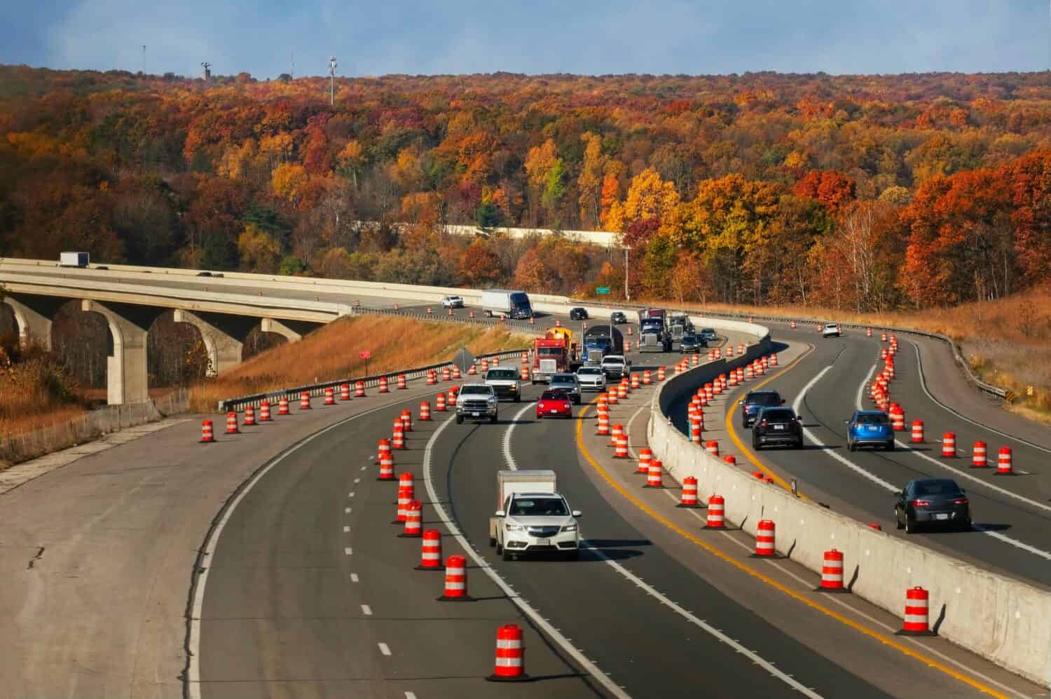 Oncoming traffic on the Ohio Turnpike rounds a curve after crossing the Cuyahoga Valley in autumn.