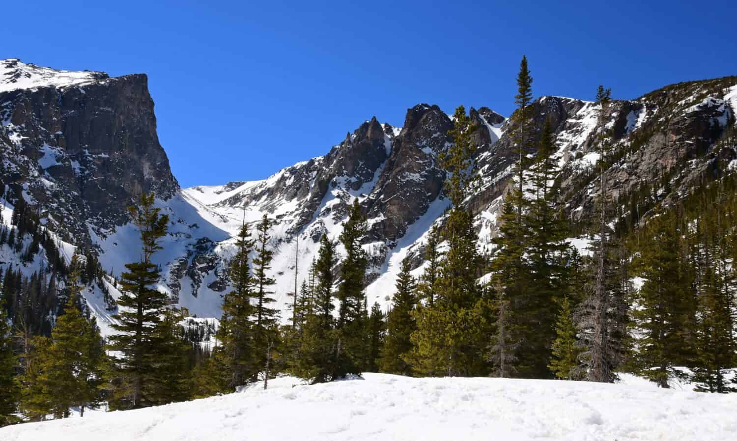 Hallett peak and flattop mountain on a sunny spring day near dream lake along the emerald lake trail in rocky mountain national park, colorado