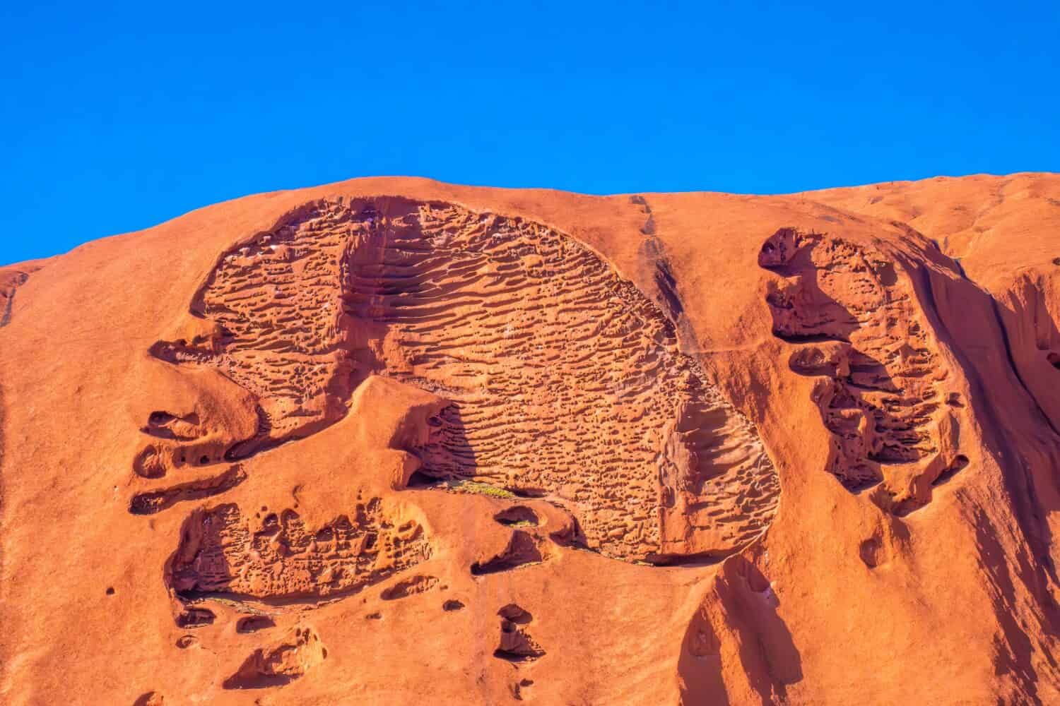 Caves and rock formations on the walls of Uluru (Ayers Rock), the iconic sandstone rock in the centre of Australia, Northern Territory, Australia