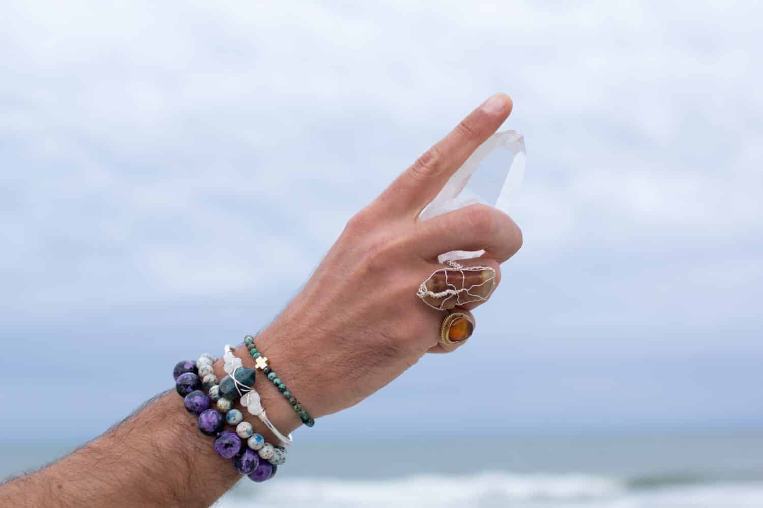 Hand holding gemstones on a beach