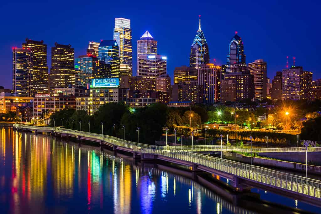 The Philadelphia skyline and Schuylkill River at night, seen from the South Street Bridge in Philadelphia, Pennsylvania.