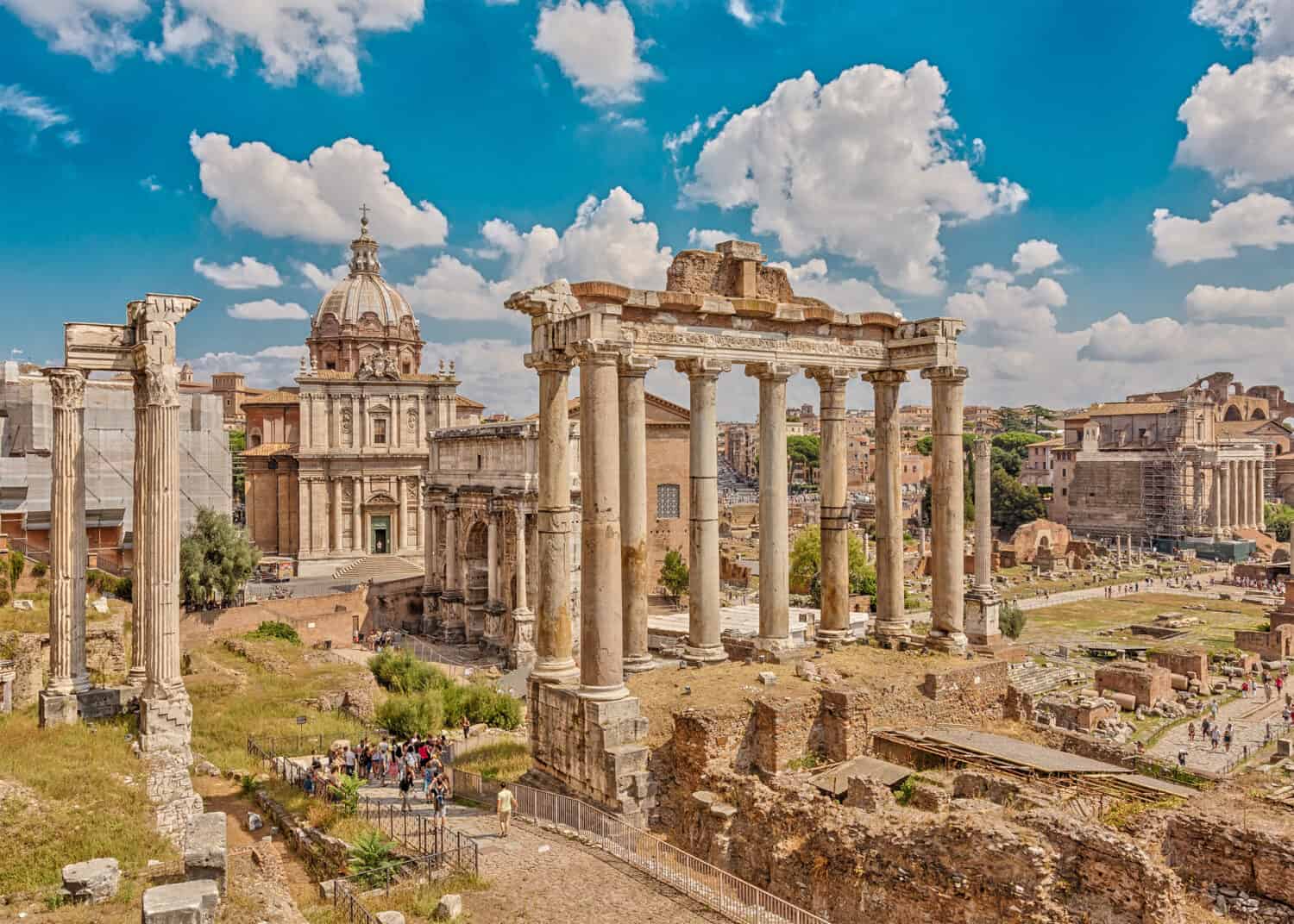 Roman Forum, in the center - the columns of the Temple of Saturn, followed by the Arch of Septimius Severus. Rome. Italy. 