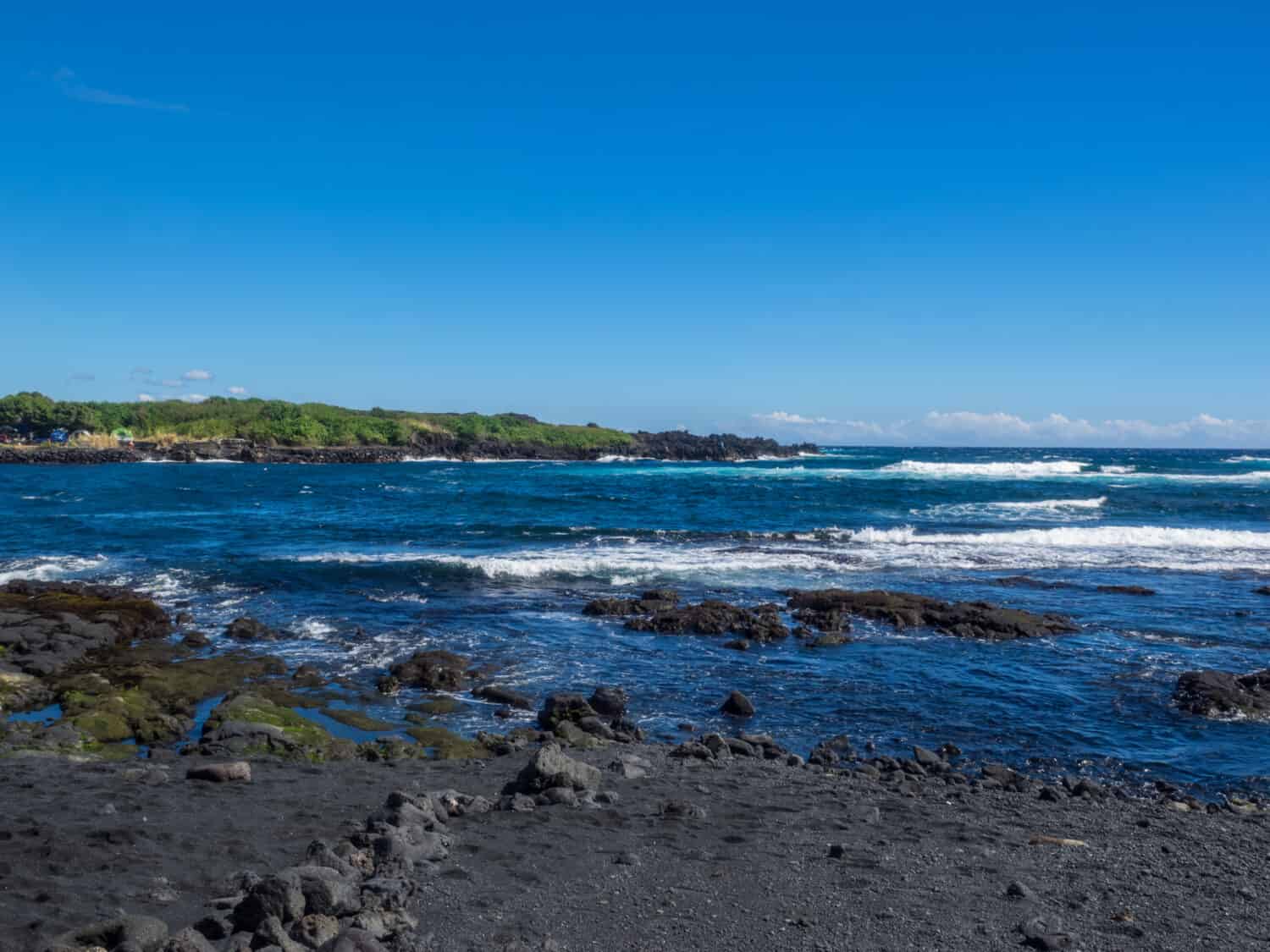 Punaluu Beach has black sand made of basalt and created by lava flowing into the ocean which explodes as it reaches the ocean and cools.