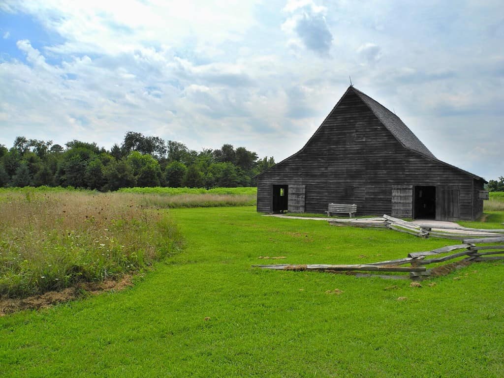 One of the old buildings in Historic St. Mary's City, which was Maryland's (United States of America) first capital city. Time stopped here in 17th century. Green grass and wooden building. Fields.