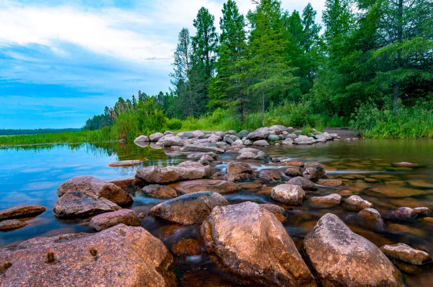 Itasca Lake held behind a man made dam at the headwaters of the Mississippi River at Itasca Lake State Park. Tourist enjoy walking across this manmade dam to say they have walked across the river. 