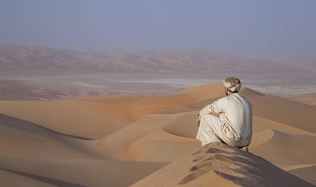 Man in traditional outfit in Empty Quarter Desert that covers a large area of UAE, KSA and Oman