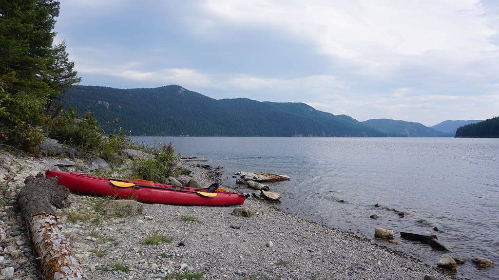 A picture of a red kayak sitting on the shore