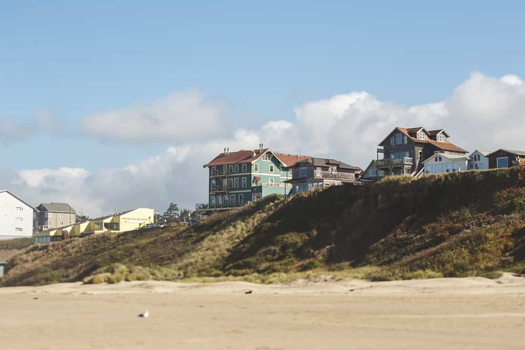 Modern houses sit on a ridge on a beach in Oregon. Partly cloudy summer day at Nye Beach, Newport, Oregon.