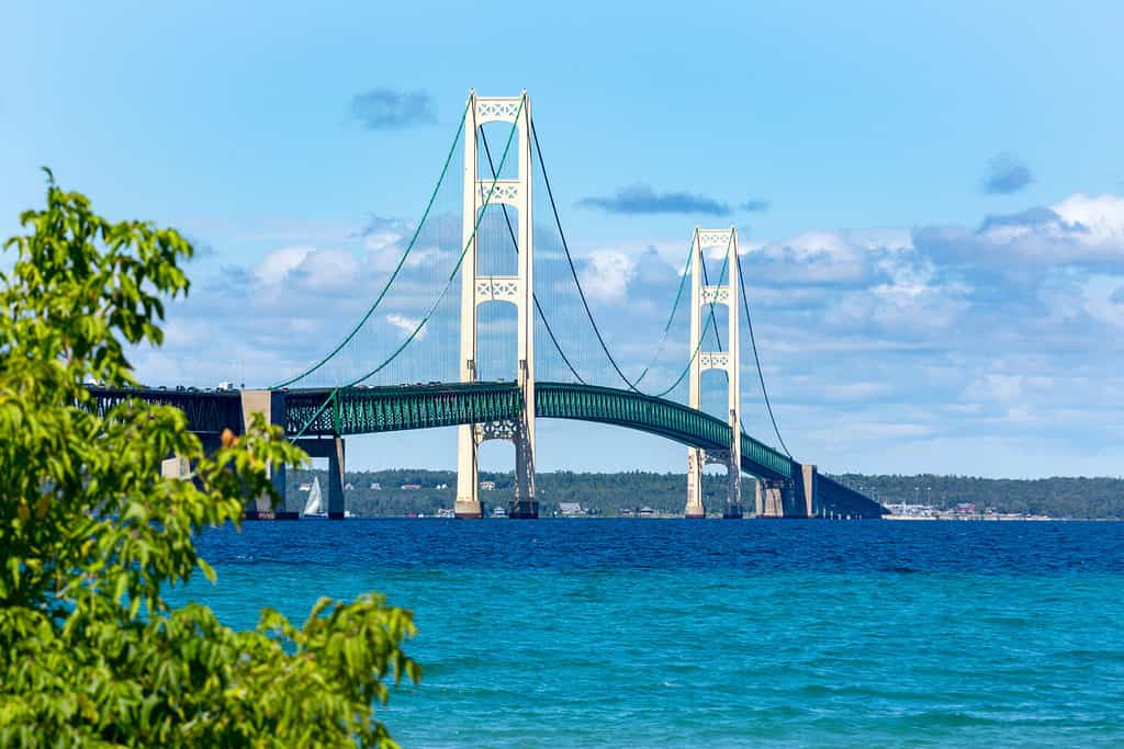 The Mackinac Bridge on a summer day. A suspension bridge spanning the Straits of Mackinac to connect the Upper and Lower Peninsulas of Michigan. Puffy clouds in a blue sky