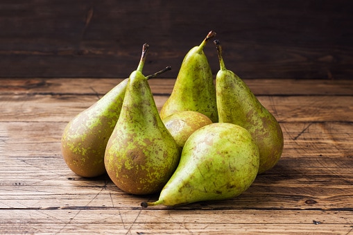 Fresh juicy Pears Conference on wooden rustic background.