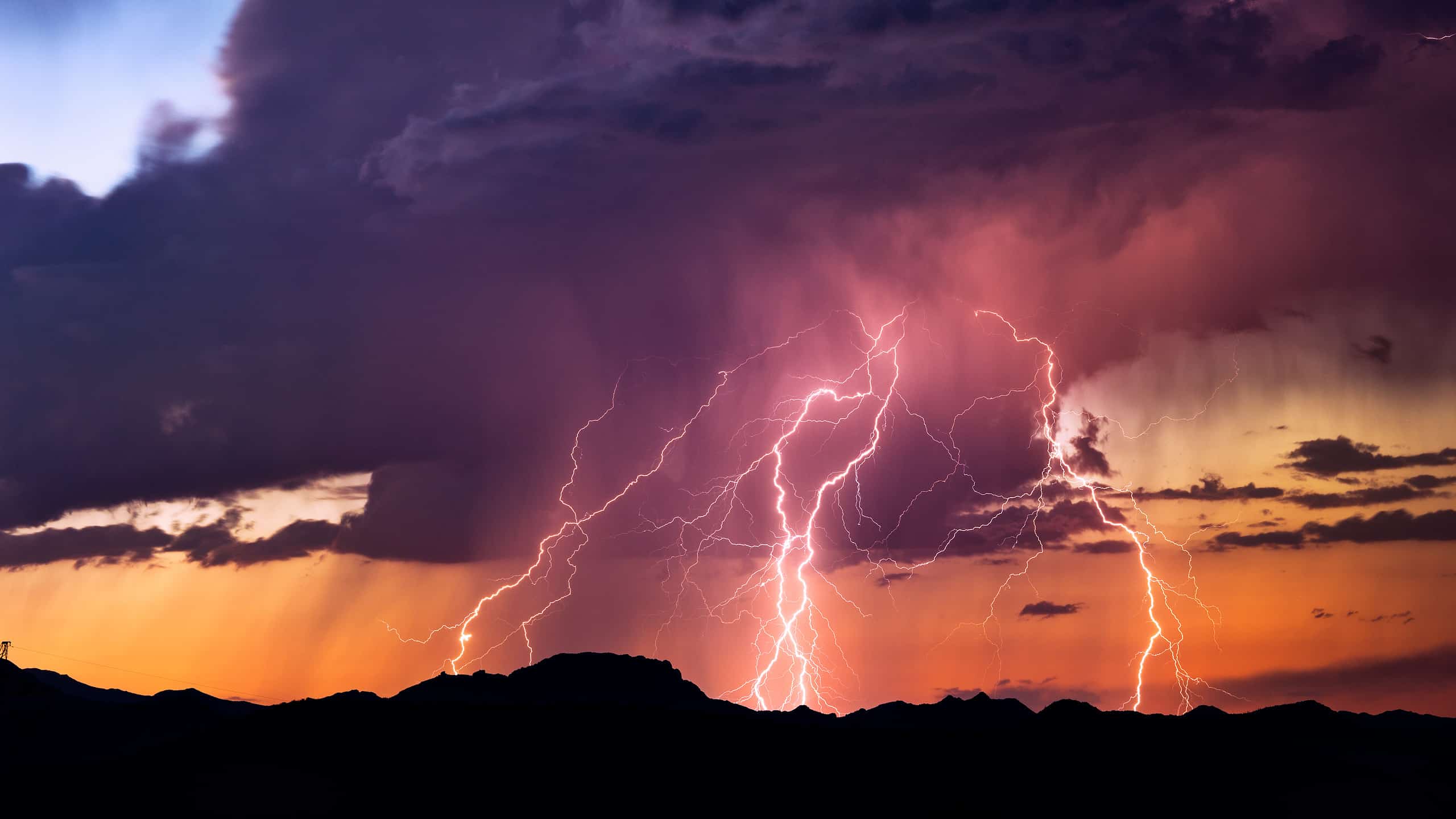 Lightning bolts strike from a sunset storm
