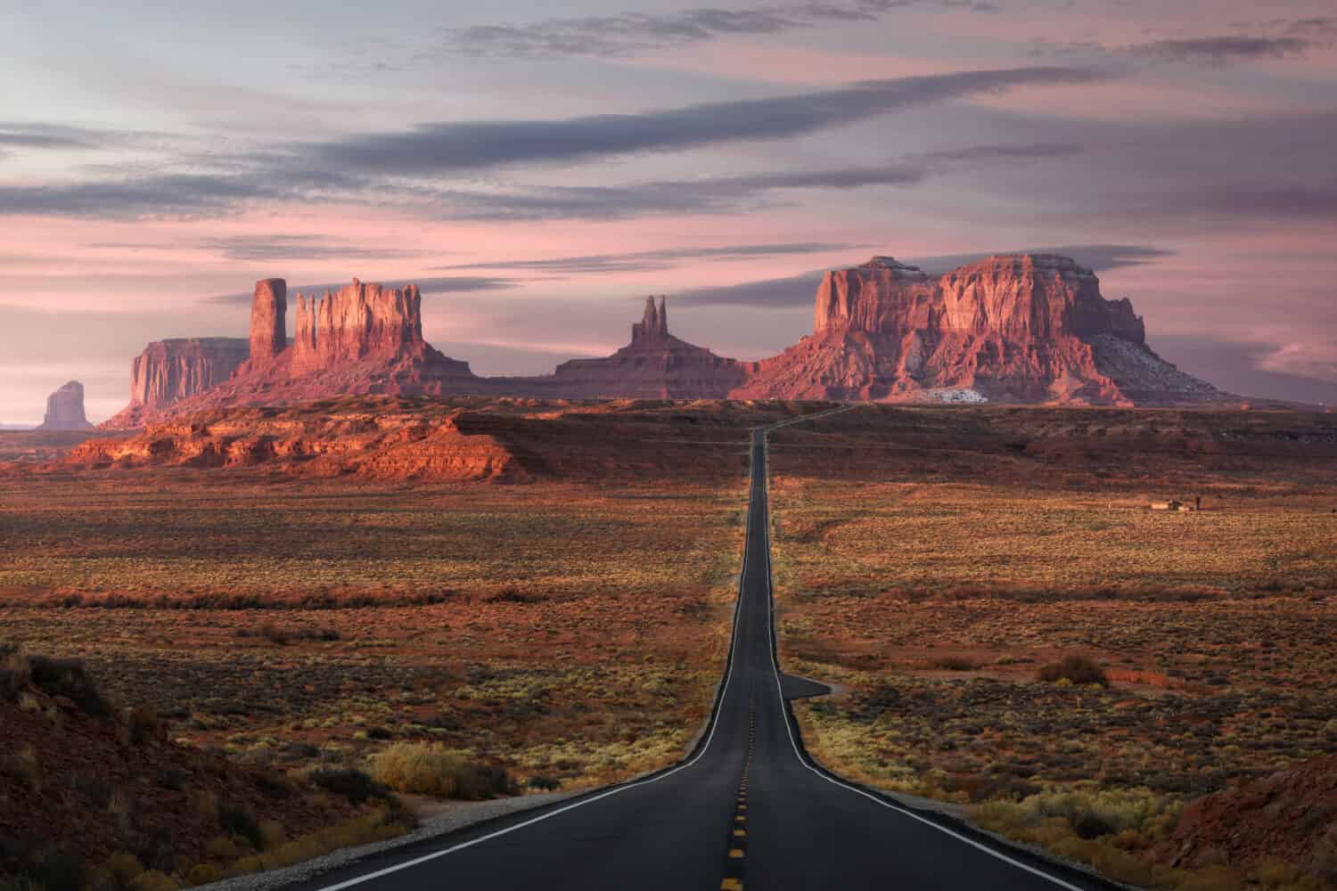 Forrest Gump Point, red rock at Monument Valley, Navajo Tribal Park, Arizona USA. Stunning view and scenic road in Utah during sunrise. Depth of long empty road.