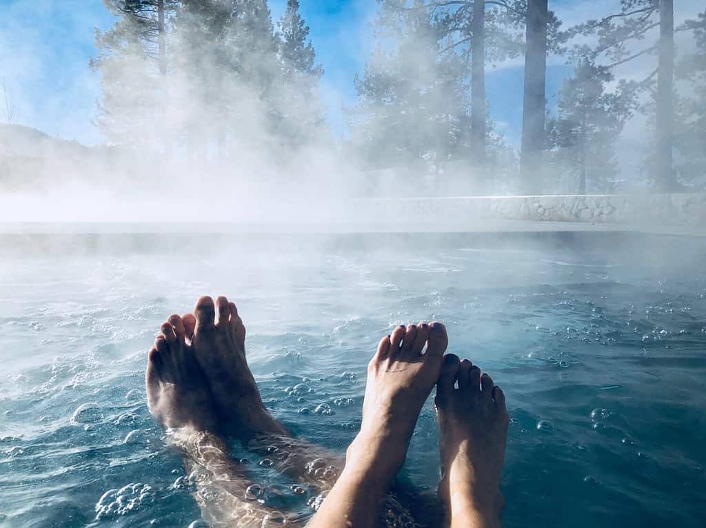 Couples Feet in Hot Tub Jacuzzi Spa Outdoors with Mist Romantic Getaway