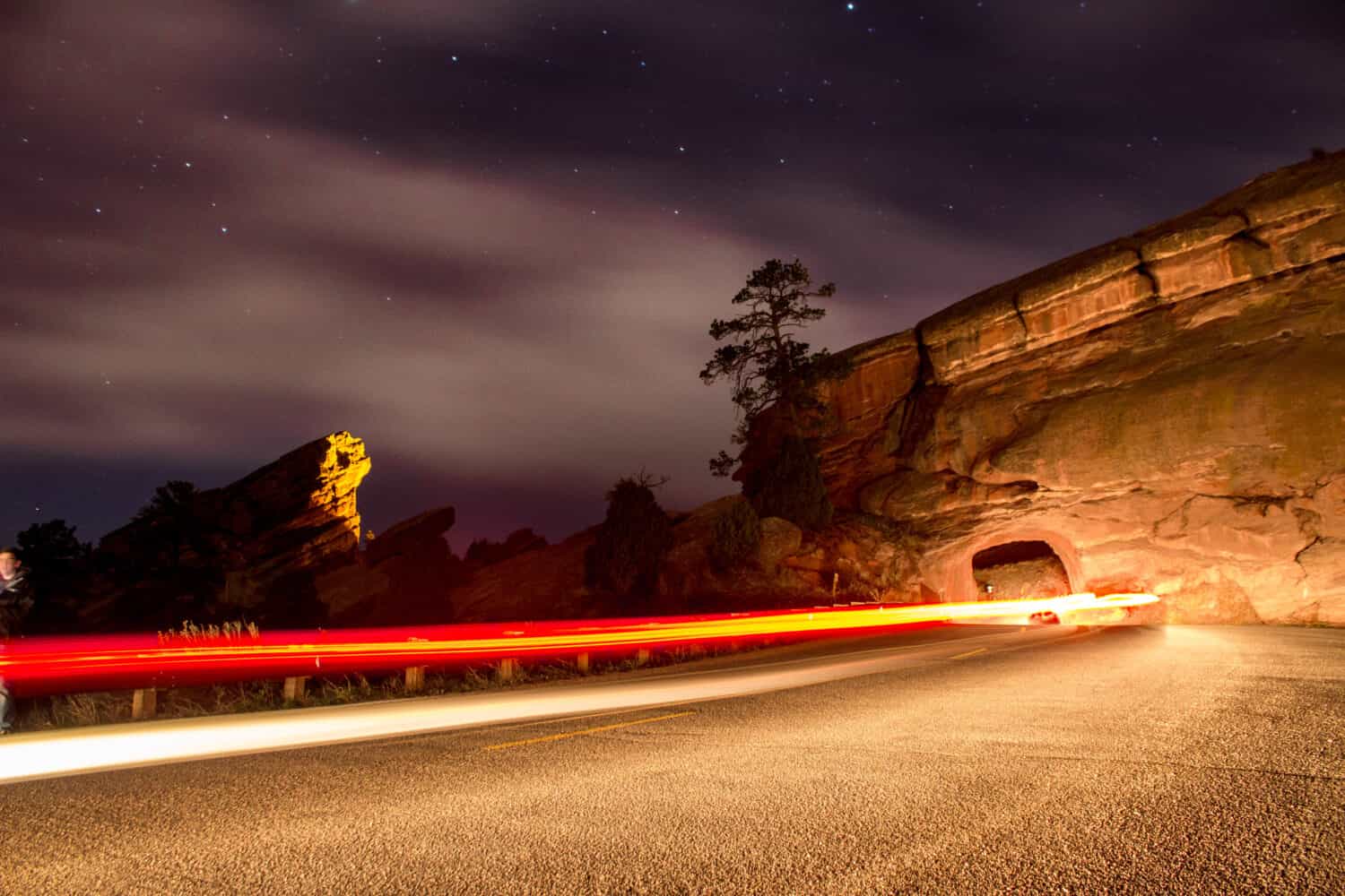 Light trails of a car passing through a tunnel at Red Rocks Park and Ampitheater outside Denver Colorado