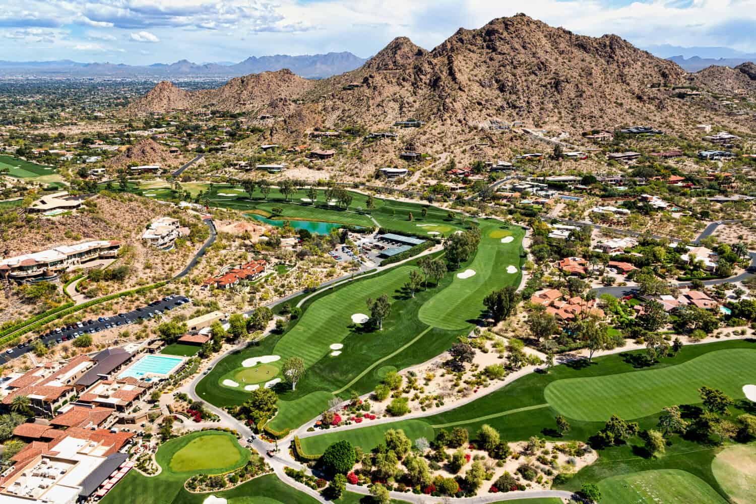 Aerial view from above a scenic golf course in Paradise Valley, Arizona looking to the northeast at Mummy Mountain and the McDowell Mountains in the distance