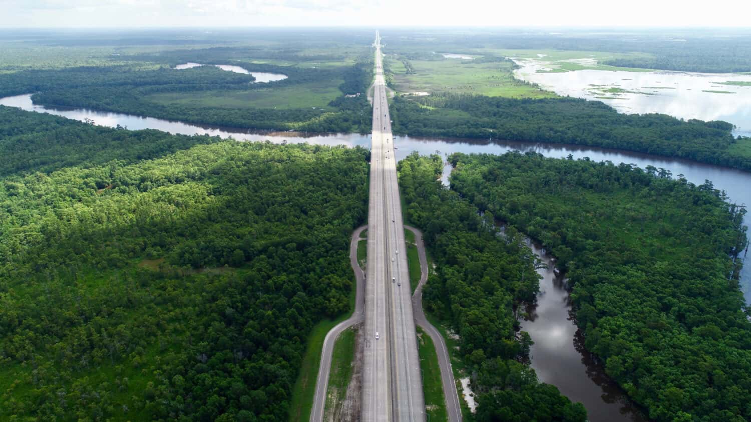 Busy highway surrounded by trees and a the gorgeous, curving, Sabine river. This river is at the border between Texas and Louisiana.
