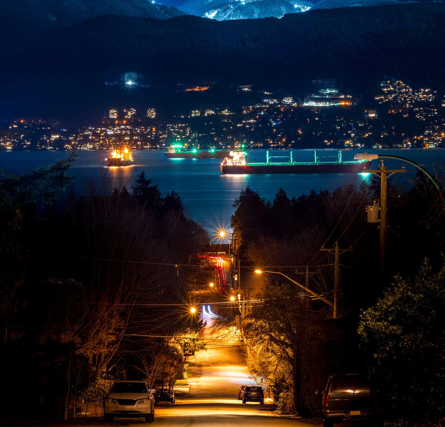 VANCOUVER MOUNTAIN SCAPE AT NIGHT - Beautiful scene of urban city street light, looking downhill on ships in harbour. Stunning view in distance. Grouse Mountain in Vancouver, British Columbia, Canada