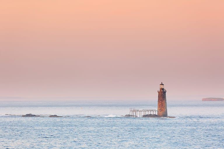 Ram Island Ledge Lighthouse at sunset, Portland Maine. The light is a lighthouse in Casco Bay, Maine, United States, marking the northern end of the main channel leading the harbor of Portland, Maine.