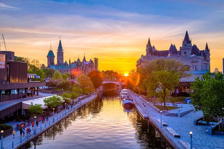View of Ottawa city buildings and Rideau canal from Mackenzie King bridge during sunset