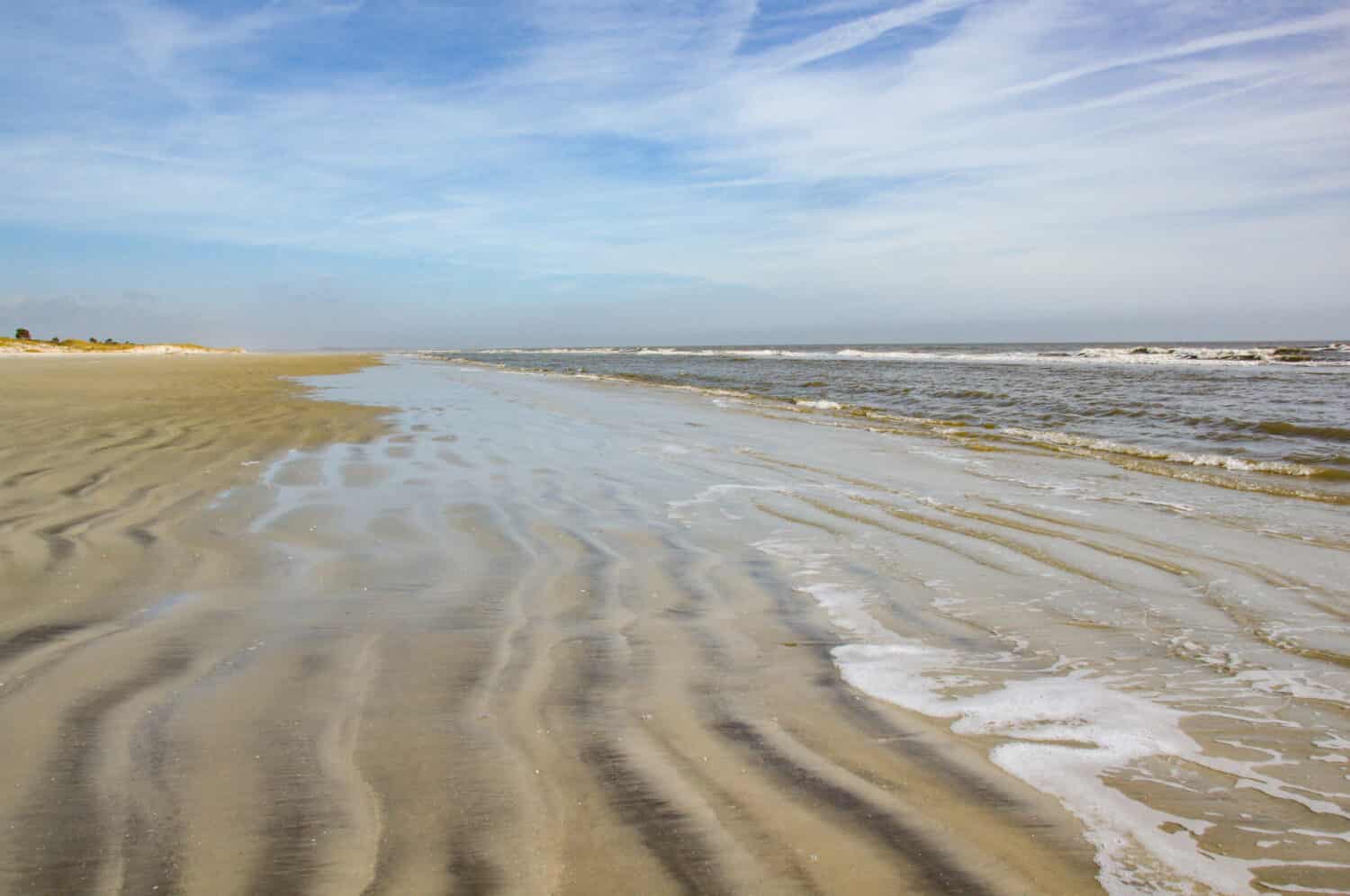 A beach without any people.  The gentle waves roll in on the rippled sand on Sapelo Island, SC.