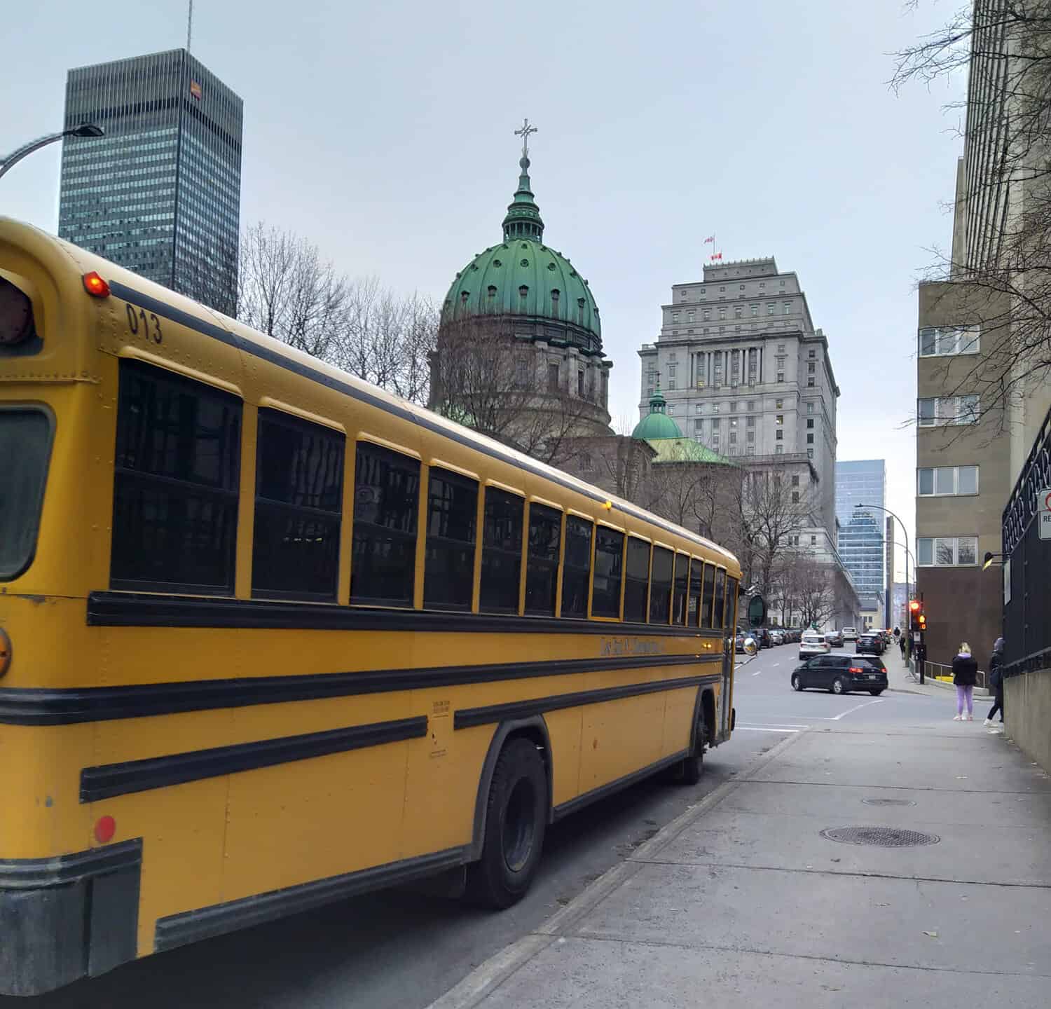 photo of Montreal city appears School bus, high governmental buildings and cathedral 