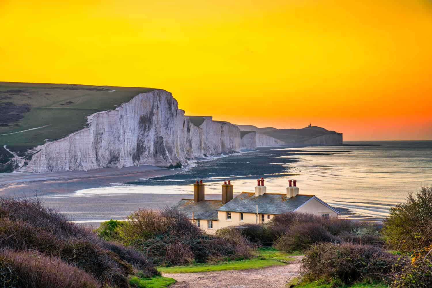 The Coast Guard Cottages and Seven Sisters Chalk Cliffs at sunrise in Sussex, England, UK
