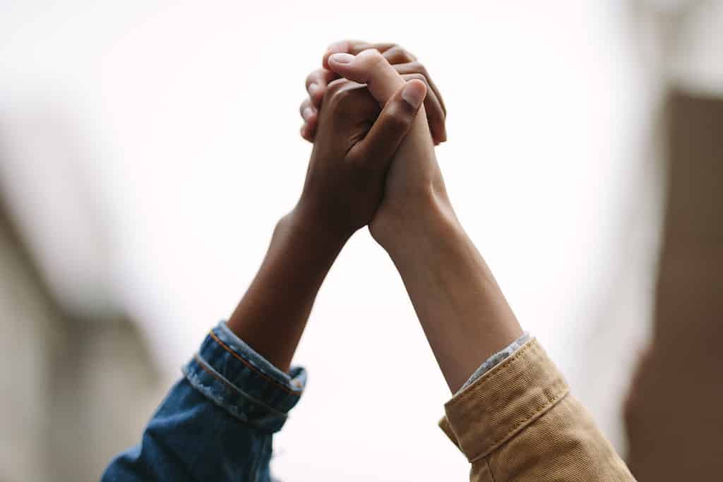 Black lives matter. Symbol of unity. Two women activists holding hands. Demonstrators protesting together holding hands.