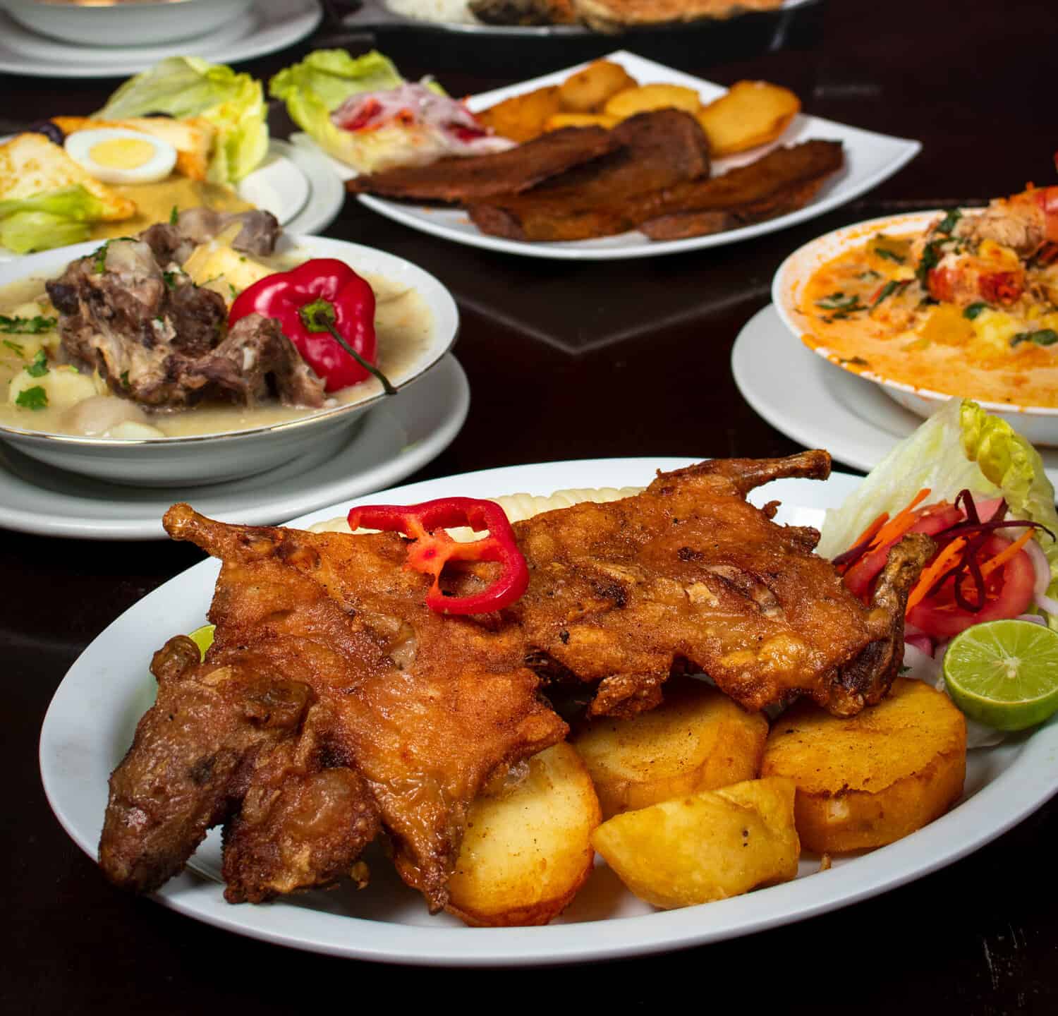 Cuy chactado, Peruvian dish on a wooden table and other food from Arequipa