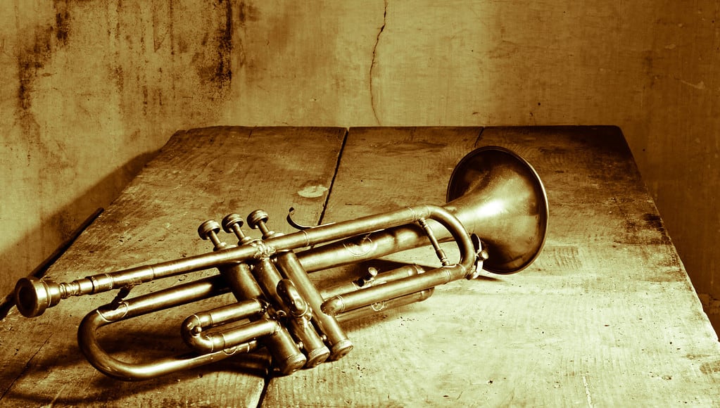 an old jazz trumpet on an antique table
