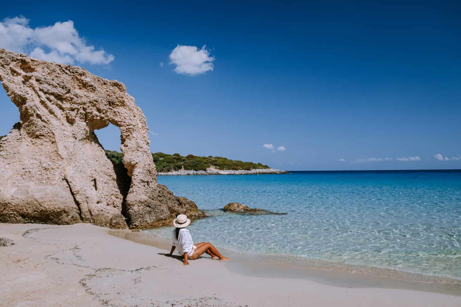 Tropical beach of Voulisma beach, Istron, Crete, Greece ,Most beautiful beaches of Crete island -Istron bay near Agios Nikolaos young asian woman mid age on vacation Greece Crete
