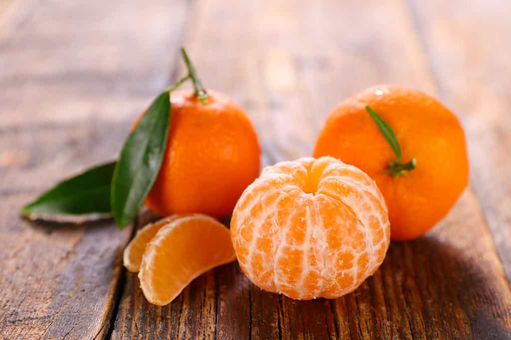 clementine and leaf on wood background