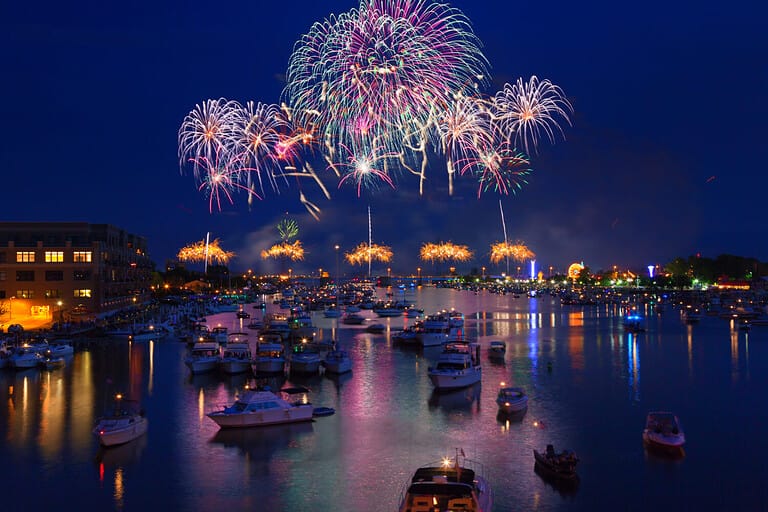 Fireworks explode in a glorious display over the Saginaw River at Bay City Michigan's annual fireworks show. Crowds gather in boats on the river to watch the display and celebrate Independence Day.