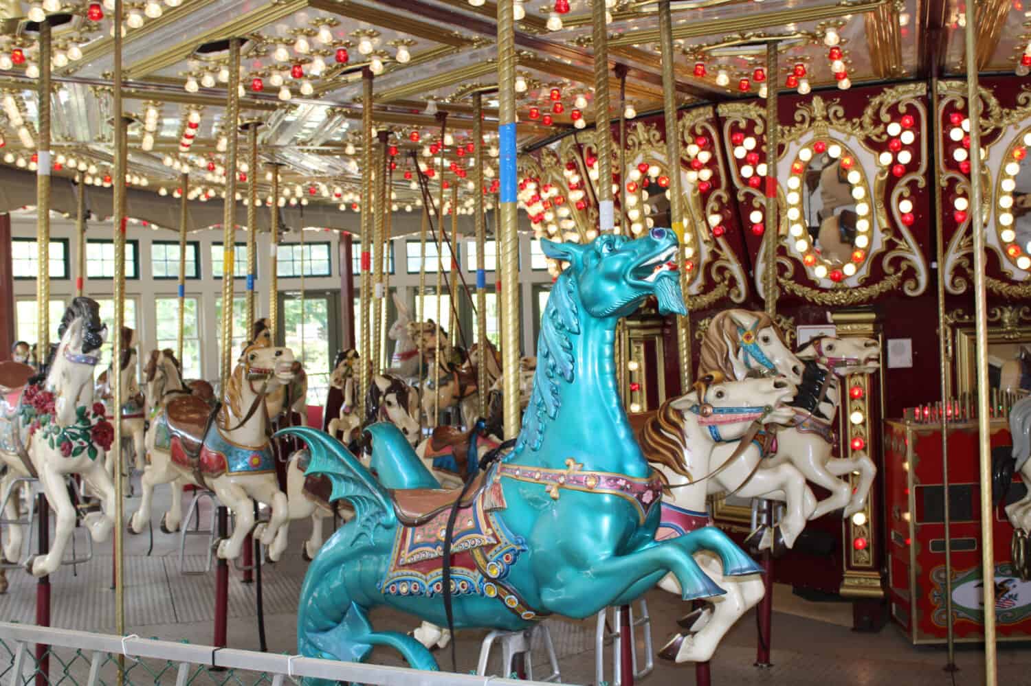 The modern carousel at the Roger Williams park in Providence, Rhode Island. The enclosed joy ride has a blue dragon that's front and center. He's surrounded by gorgeous, trotting, carved horses.