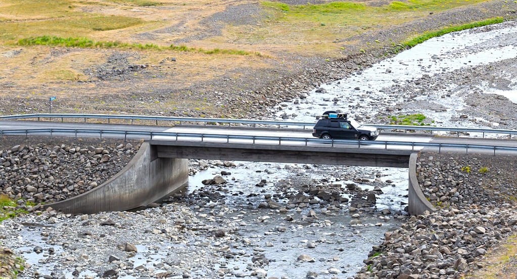 Car travelling Iceland strong old concrete bridge