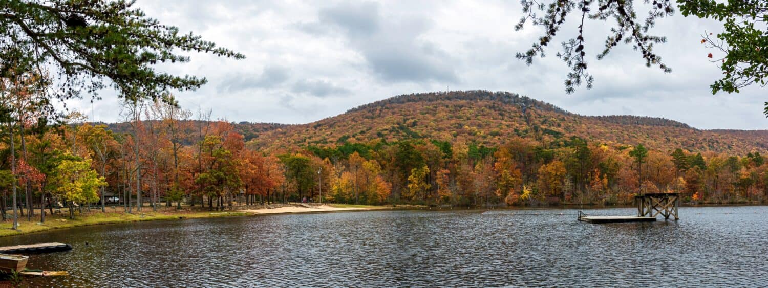 Delta, Alabama, USA- Nov. 11, 2021: Panorama of Cheaha Lake at the base of Mount Cheaha in Cheaha State Park in full autumn color.