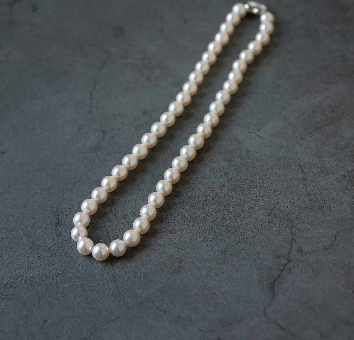 Authentic Akoya pearl necklace on rocky background