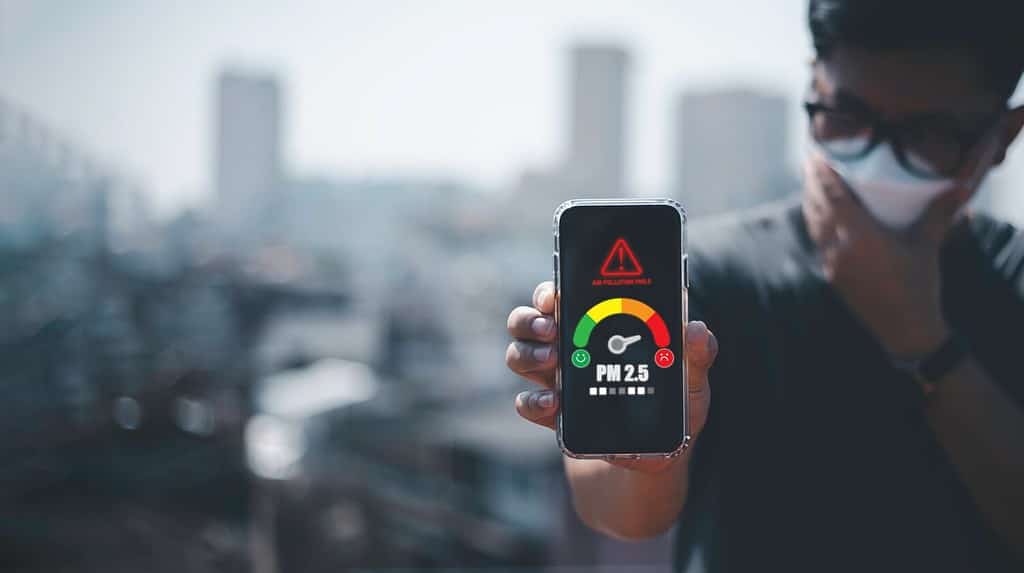 man scanning the weather on his mobile phone Ecological concept. Allergies. Headache.N95 PM 2.5 from air pollution and dust beyond safety standards. health care, environment,