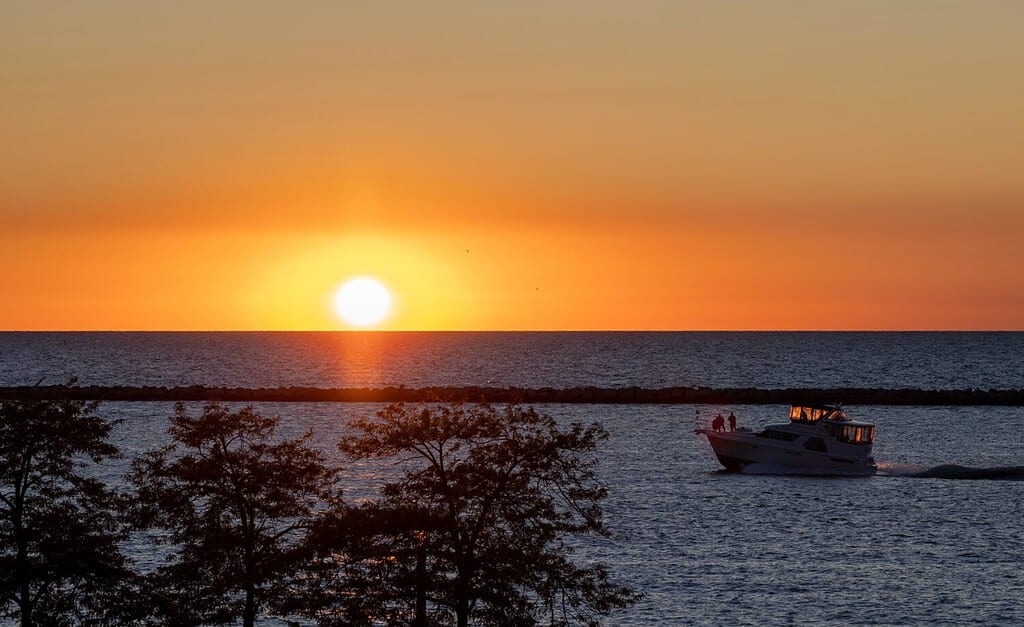 Boat shipping into the sunset on one of the Great Lakes