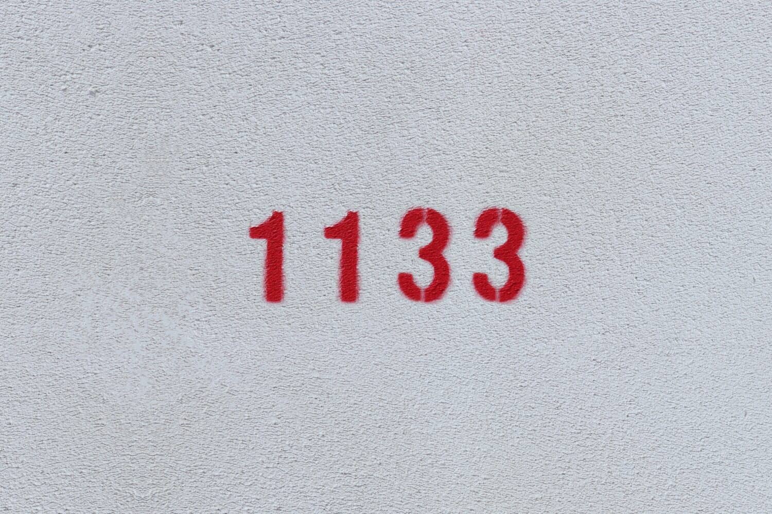 Red Number 1133 on the white wall. Spray paint.
