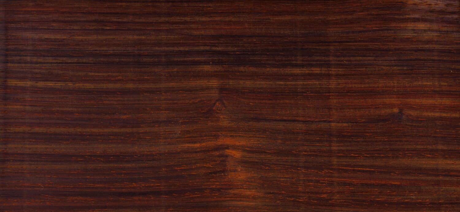 Cocobolo Dalbergia retusa is a rosewood family species. Beautiful hues of reds purples browns and a range of other dark colors. This woodgrain color chip can be used as a tileable background. 