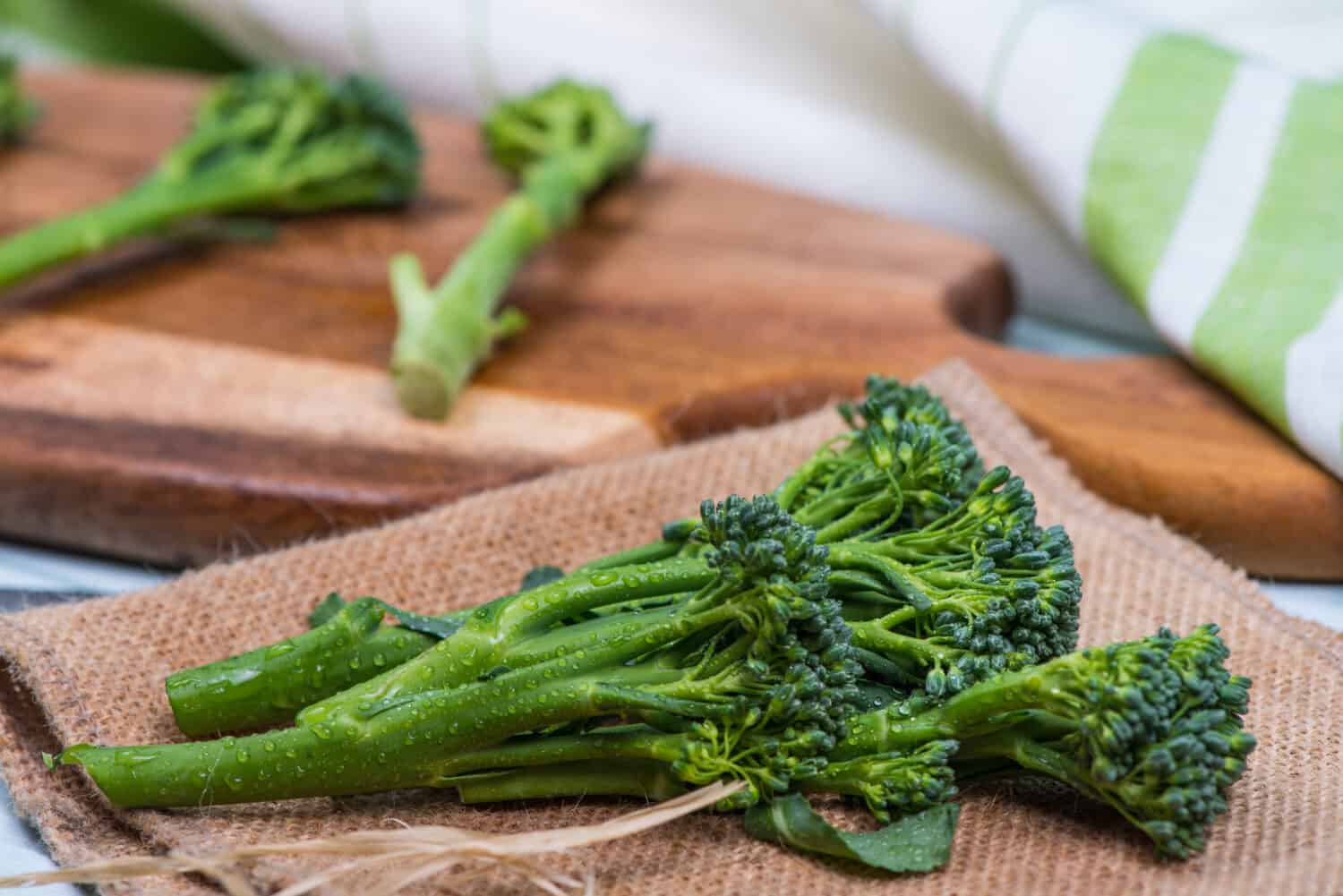 fresh green broccolini on wooden table