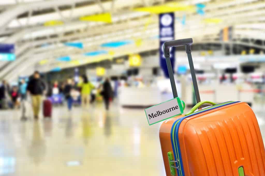 Melbourne, Australia. Orange suitcase with label at airport.