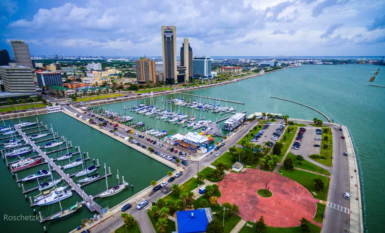 Corpus Christi Texas Skyline view of City harbor bridge in background with many rows of piers filled with boats and sailboats and yachts across the summer vacation landmark getaway