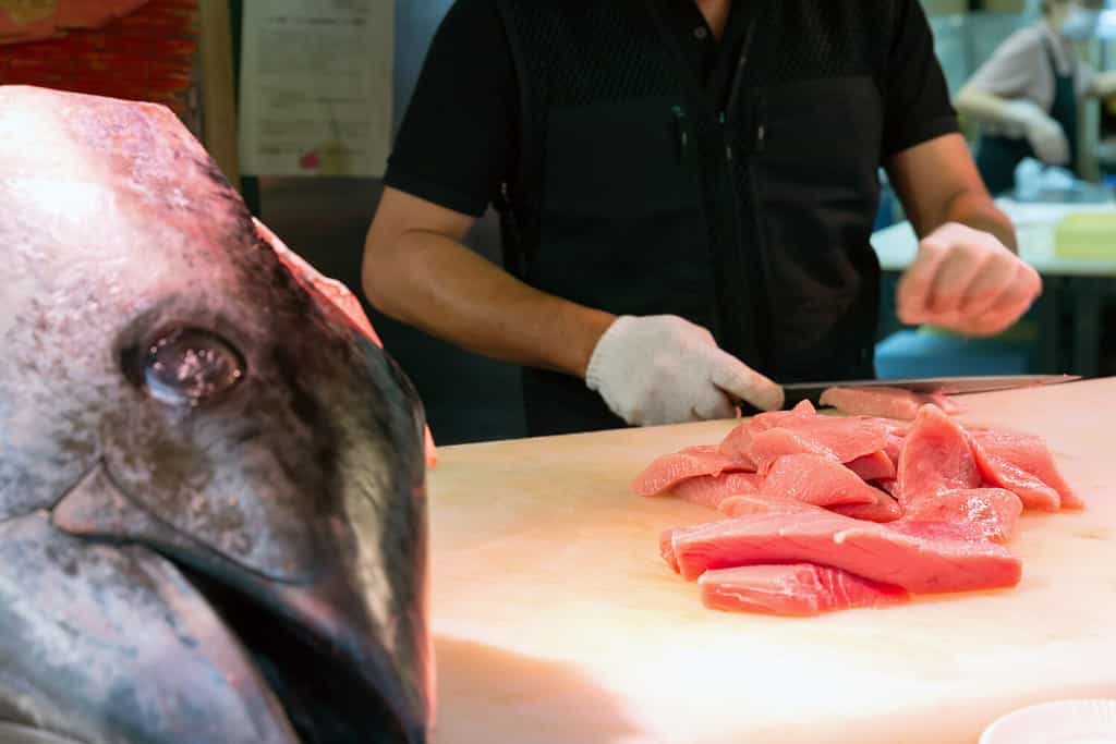 Chef cutting bluefin tuna in Kuromon Market, Osaka, Japan