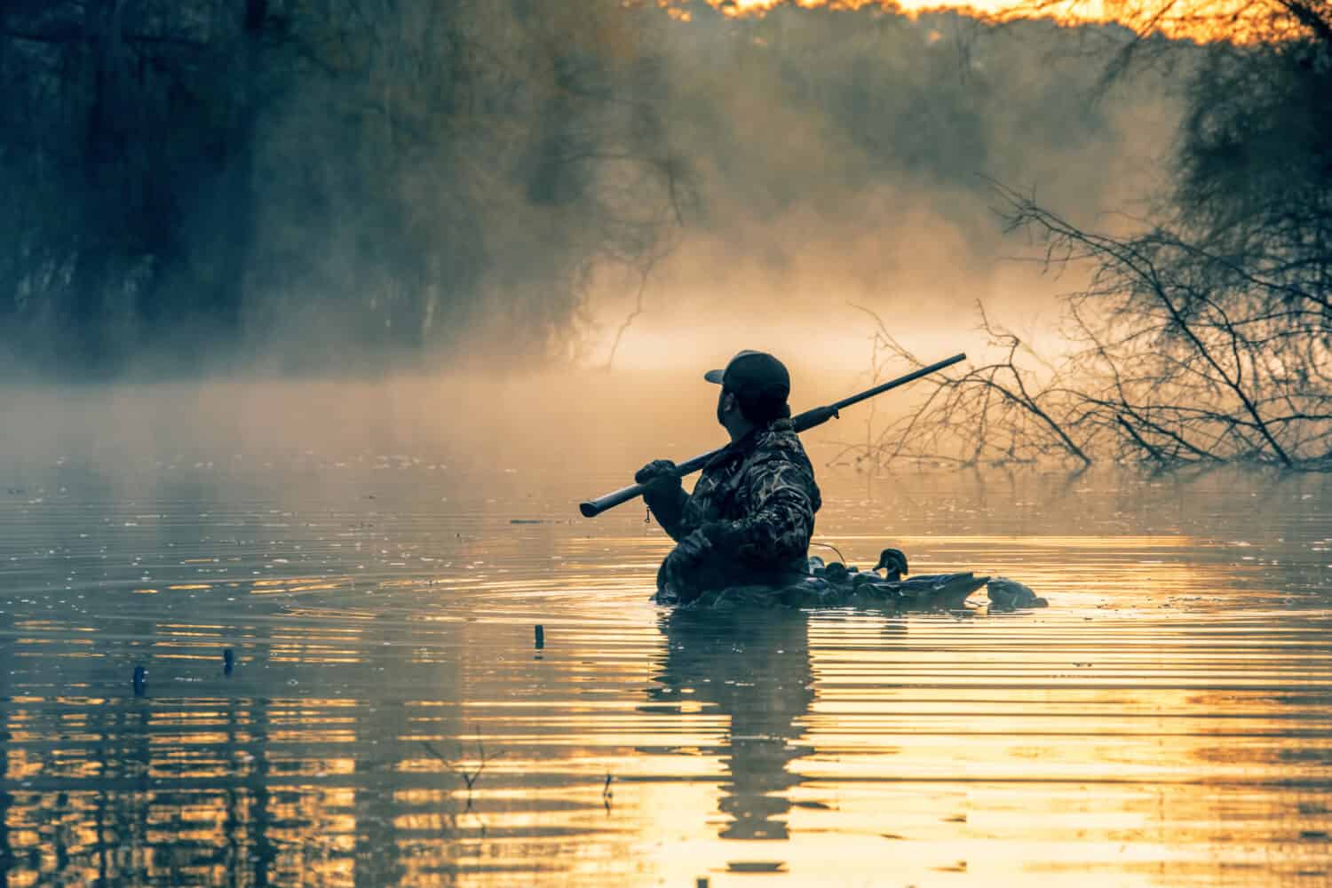 A duck Hunter in the water in full gear 